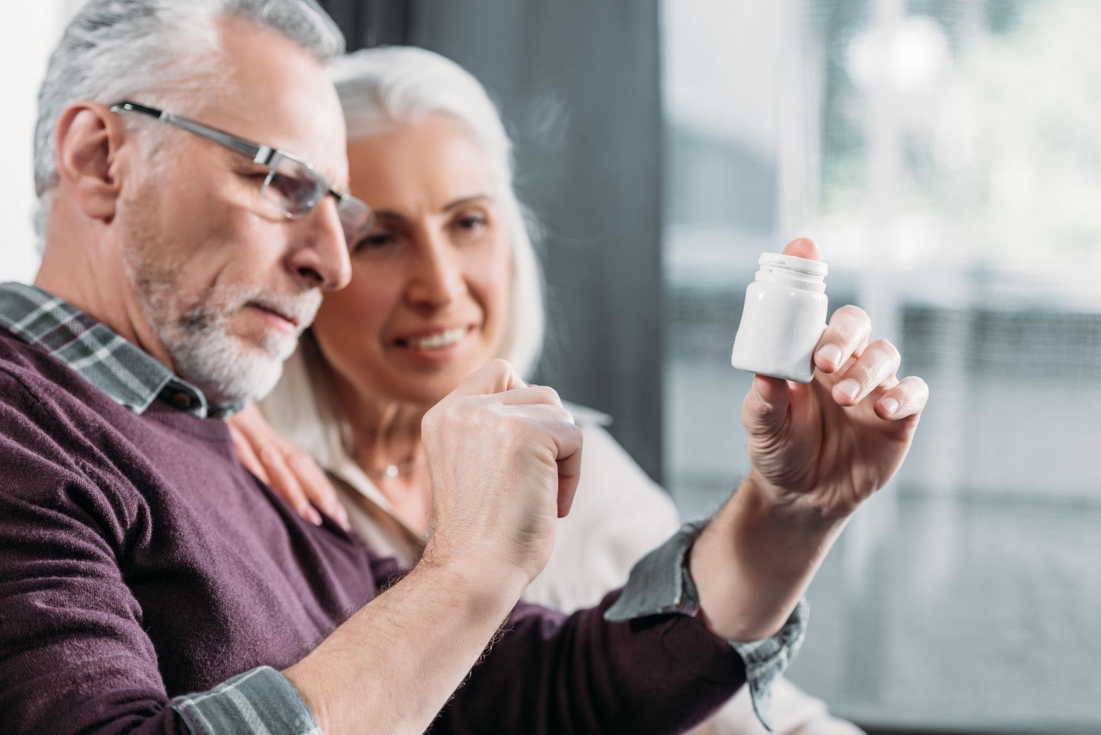 Hand of female doctor mid-section holds white pills or tablets jar mockup. Medicine and pharmacy, prescription drugs or vitamins concept. Copy space banner|||||
